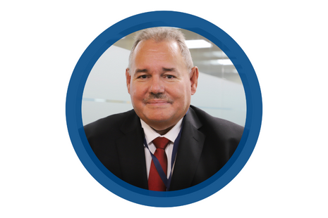 Pictured Keith Redpath grey hair with moustache wearing a black suit jacket, white shirt with burgundy tie (and navy blue lanyard)